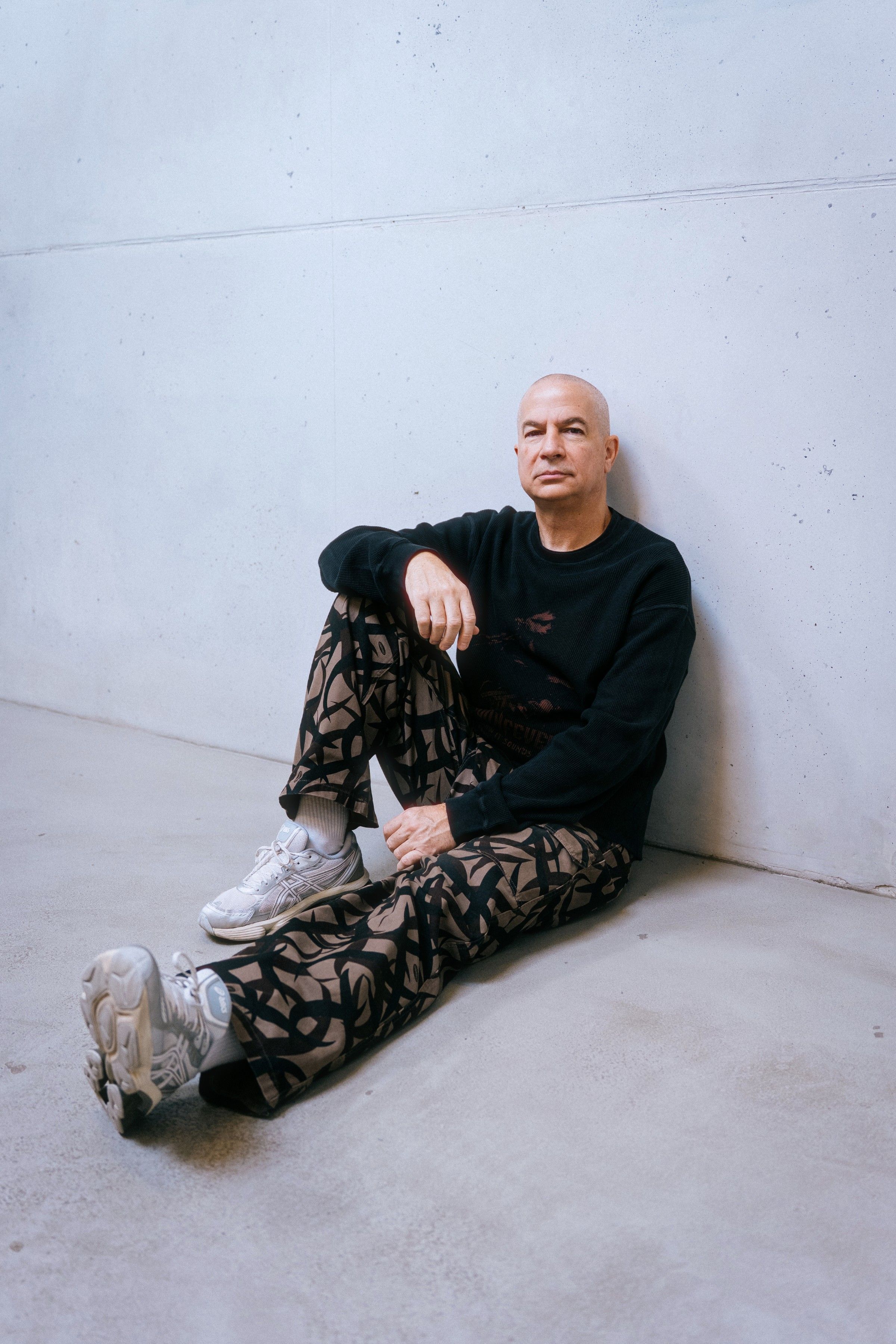 Murat Uncuoglu sitting on the floor against a concrete wall